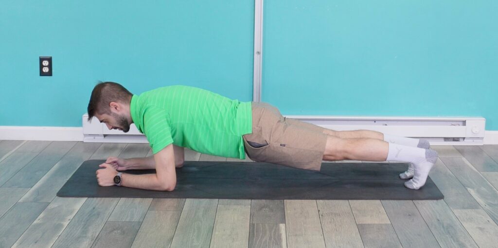 Dr. jon in an elbow or low plank preparing to push into his high plank for elbow to hand planks